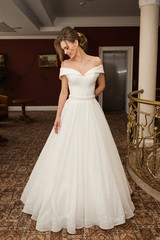 Portrait of a beautiful bride woman in elegant white wedding dress. Luxurious apartments. 