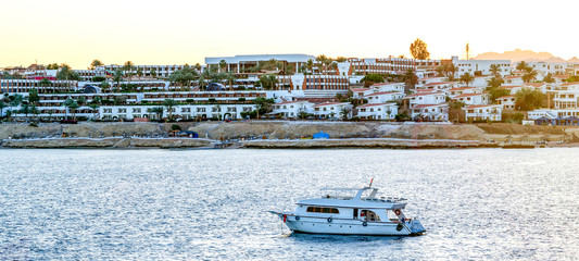 Obraz premium Beach at the luxury hotel, Sharm el Sheikh, Egypt. The beach at the luxury hotel, Sharm el Sheikh, Egypt. Yacht in the sea near the shore