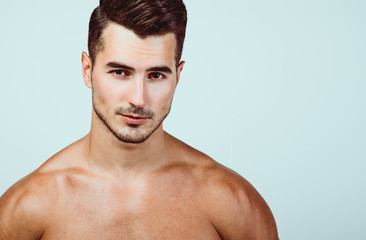 Fototapeta premium Male beauty concept. Portrait of handsome young man with stylish haircut posing over white background. Perfect hair & skin. Close up. Studio shot