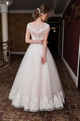 Obraz premium Beauty portrait of bride wearing fashion wedding dress with feathers with luxury delight make-up and hairstyle studio indoor photo.