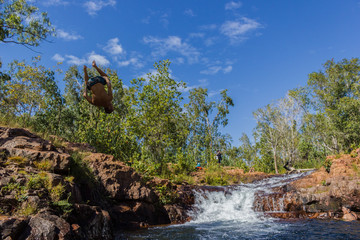 young man doing a salto in the Buley Rockhole in Litchfield National Park, Northern Territory,...
