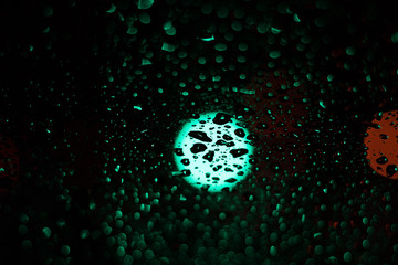 Colored drops on a glass at night