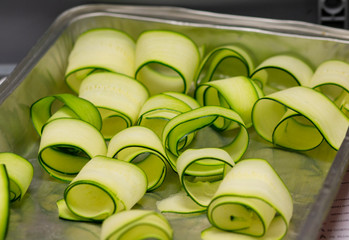 the cook twists rolls with thinly sliced zucchini