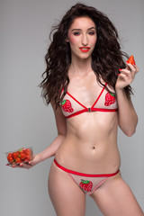 Young woman in bikini holding strawberries