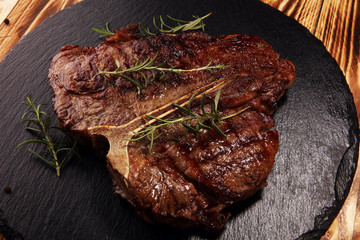 Grilled T-bone steak on stone cutting board.