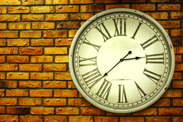 vintage clock hanging on an old brick wall