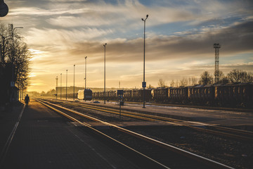 Sunset, lonely traveler walking in train station