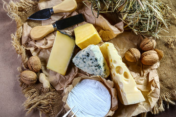 Italian cheese assorted, cheese with blue mildew, Camembert or brie cheese circle and nuts, Cheese Serving Knife. top view, copy space