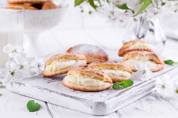 Homemade buns stuffed with cottage cheese on a wooden background
