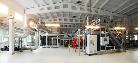 Gas boiler, control cabinet and pipes for the supply of gas and steam. Panoramic view of boiler room