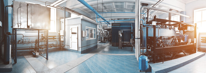 Interior of the boiler room with gas disassembled boiler and pipes for supplying gas and steam. Blue tonting with sunflare. Panoramic view