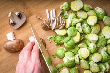 Brussels sprouts and mushrooms on cutting board, top view