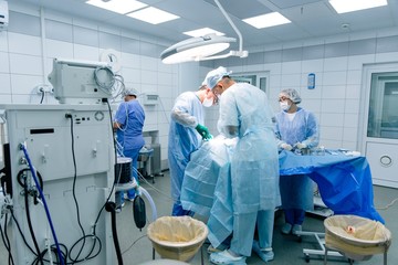 Team of professional surgeons operating on patients with diseases