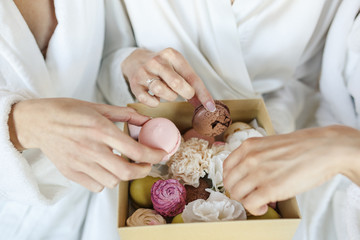 young beautiful wedding bride with her bridesmaids eat macaroon cakes