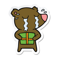 sticker of a cartoon crying bear with present