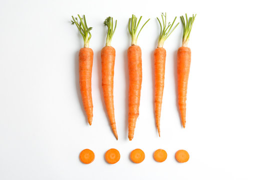 Flat lay composition with ripe fresh carrots on white background
