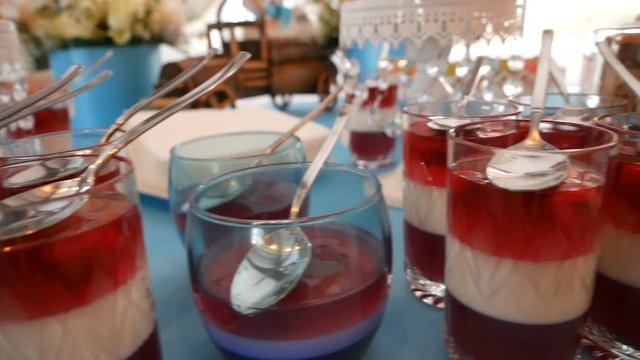 Tasty red and white jelly in glasses with spoons