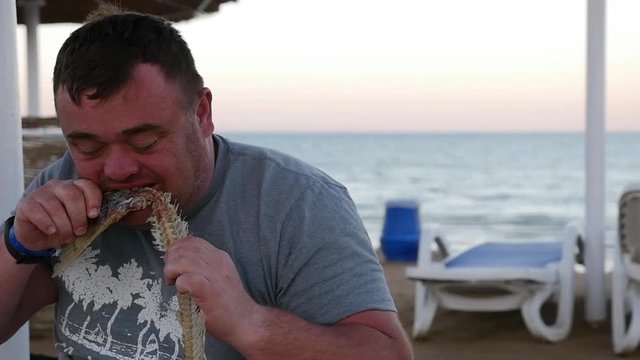 Man eating dried fish.