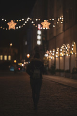 woman in black dress on street of city at night