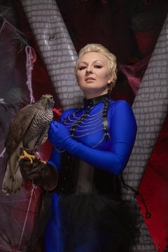 beautiful scary woman with the big hawk best friend on the background of dark room