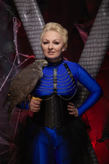 beautiful scary woman with the big hawk best friend on the background of dark room