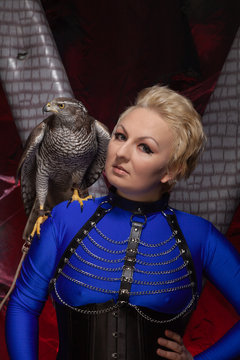 beautiful scary woman with the big hawk best friend on the background of dark room