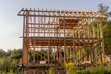 wooden interior frame of a new house under building, architectural residential construction stick built home framework.