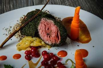 closeup medium raw meat in dill decorated with carrot and viburnum berries