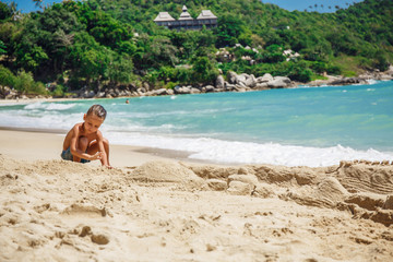 Fototapeta na wymiar little boy built a sand castle 