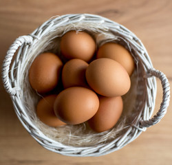  Fresh eggs in wicker basket  on wood table Prepare chicken eggs and egg whisk for cooking or bakery can use for background or wallpaper.
