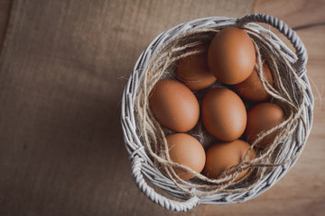  Fresh eggs in wicker basket  on wood table Prepare chicken eggs and egg whisk for cooking or...