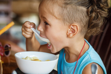 beautiful boy is having breakfast with  porridge 