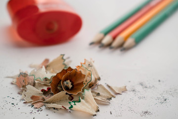colour pencils pile of sawdust and red sharpener on a white background