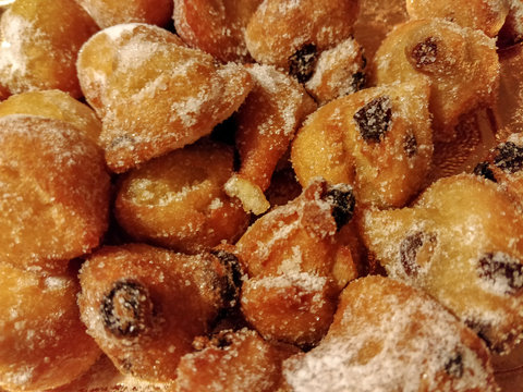 Sweet typical italian fritters (Frittelle or Frittole) with raisins and sugar