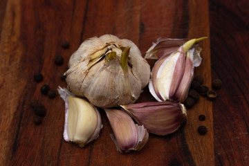 Fresh garlic and pepper on wooden board