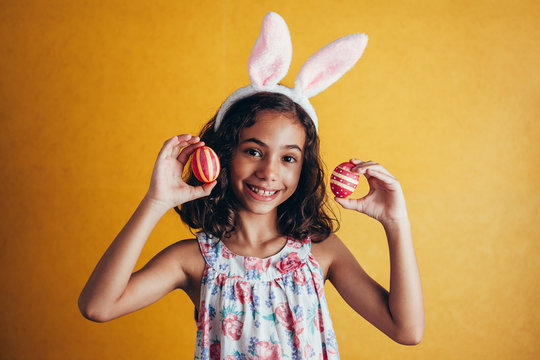 A happy girl showing decorated easter eggs