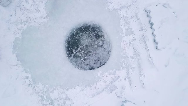 Set of three clips of the young man jumping into the ice hole. Three different angles of one action