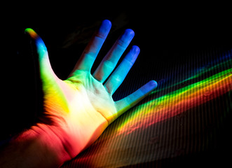 Prism dispersed light illuminating open hand