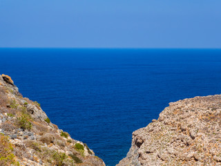 View of endless blue sea, two rocky hills meet in the foregorund