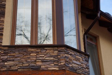 large window on a brown stone attic wall