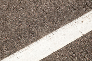 Fototapeta premium White line at an angle on asphalt. Bicycle and walking lane. Part of the stadium. white paint on the pavement.