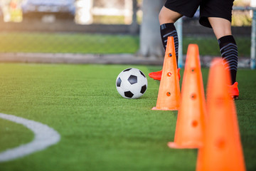 soccer player jogging with trap and control football