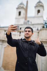 Self portrait of handsome young man in casual wear smiling while standing outdoors