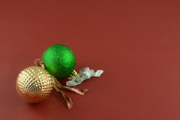 Red and gold Christmas ball ornaments with ribbon ties on red background
