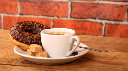 Coffee white cup, croissants on wooden table and roasted coffee beans. Breakfast concept