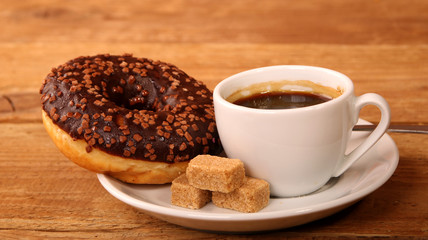 Coffee white cup, croissants on wooden table and roasted coffee beans. Breakfast concept