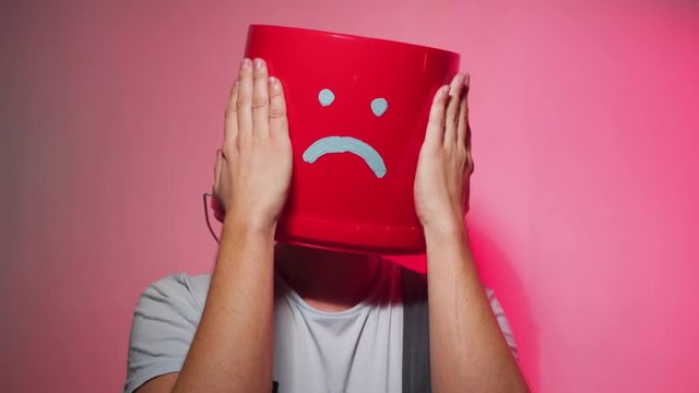 Worker in uniform with red bucket on his head sad.