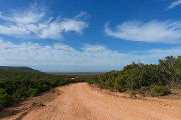 Wide dirt road on sunny day landscape