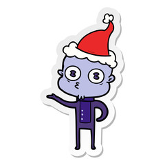 sticker cartoon of a weird bald spaceman wearing santa hat