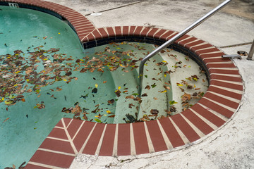 Dirty pool sits unattended covered in leaves